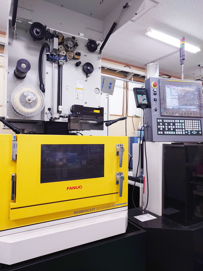 細いワイヤー（電極線）を使って金属を切断する加工機の画像